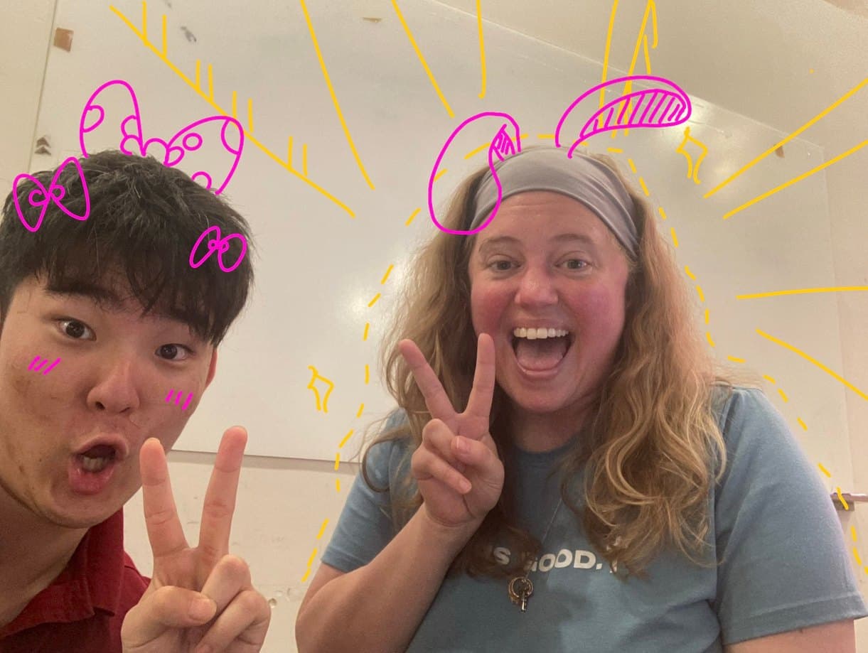 Two members of the Valor community pulling faces for the camera, drawn over in pink and yellow marker