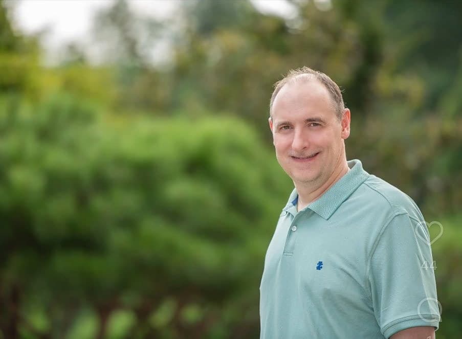 Mr. Knickerbocker photographed outdoors in front of greenery